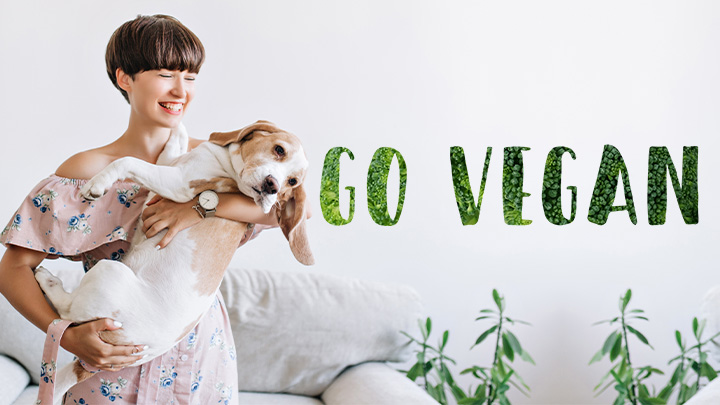 djevojka drži psa pored natpisa go vegan